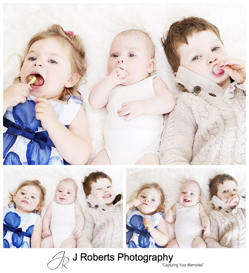 Baby boy with his big sister and brother licking lollipops - sydney baby portrait photography
